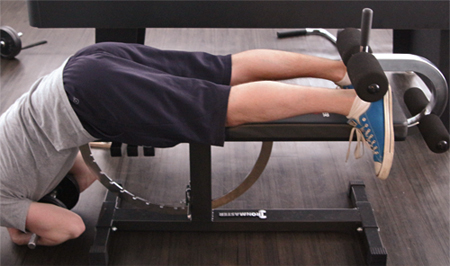 Back hyperextensions on an Ironmaster Bench with Crunch Attachment