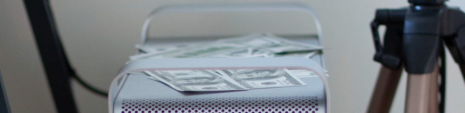 Dollars and twenties on top of a computer.